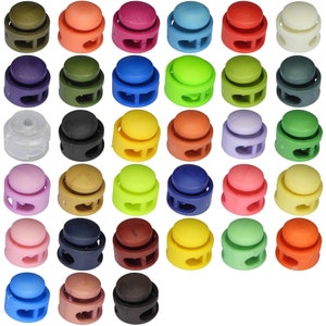 May include: Assortment of 30 plastic toggle clasps in various colours, including black, white, red, blue, green, yellow, brown, and pink. The clasps are designed for use with cords, straps, or other materials.