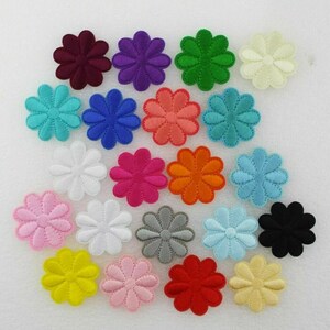 May include: Assortment of 20 colourful felt flower appliques. Each flower is approximately 1.5 inches in diameter and has a 7-petal design. The colours include red, pink, orange, yellow, green, blue, purple, white, black, and grey.