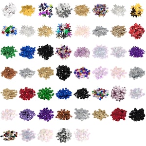 May include: Assortment of colourful sequins in various shapes and sizes, including round, square, and star-shaped sequins. The sequins are arranged in rows on a white background.