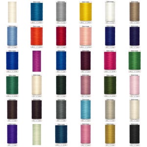 May include: A selection of Gutermann sewing thread spools in a range of colours. The spools are cylindrical, with a white label and blue text. Colours include blue, red, pink, green, and yellow. Each spool is labelled with the Gutermann brand.