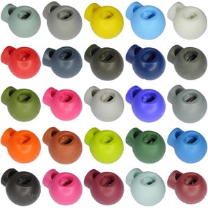May include: Assortment of 24 plastic toggle stoppers in various colours, including red, blue, green, yellow, brown, grey, and black. The stoppers have a round shape with a small hole in the centre.