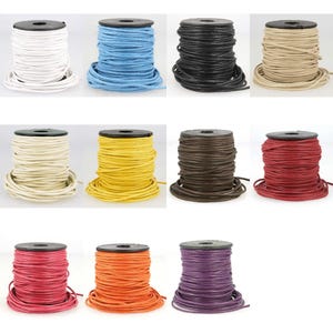 May include: Ten spools of leather cord in a variety of colours, including white, blue, black, beige, cream, yellow, brown, red, orange, and purple. The spools are all the same size and have a black plastic base.