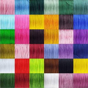 May include: A collection of colourful cords in various shades of green, blue, pink, yellow, red, brown, purple, and white. The cords are arranged in a grid pattern.