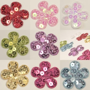 May include: Assortment of ten flower-shaped fabric patches with sequins. The patches are in various colours, including pink, blue, green, yellow, and red.