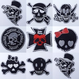 May include: Nine embroidered iron-on patches featuring skull designs. The patches are black with white and silver accents. Some patches feature a pirate hat, a bow, and a cross.