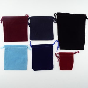 May include: Six velvet drawstring pouches in various colours, including red, blue, and black. The pouches are all small and would be suitable for holding jewellery or other small items.