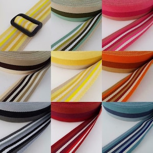 May include: Assortment of striped webbing in various colours, including yellow, orange, red, blue, green, and grey. The webbing is approximately 2.5 cm wide and has a woven texture.