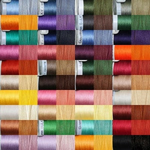 May include: A collection of spools of thread in various colours, including orange, green, purple, blue, brown, red, yellow, pink, beige, and white. The spools are labelled with the brand name "Gütermann Sulky" and "Ann Sulky".
