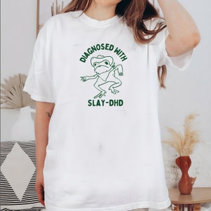 Diagnosticado con slay dhd Camiseta de algodón pesado unisex, ropa de viaje divertida de boneyisland imagen 1