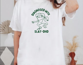 Diagnosticado con slay- dhd Camiseta de algodón pesado unisex, ropa de viaje divertida de boneyisland