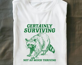 certainly surviving not so much thriving Unisex Heavy Cotton Tee