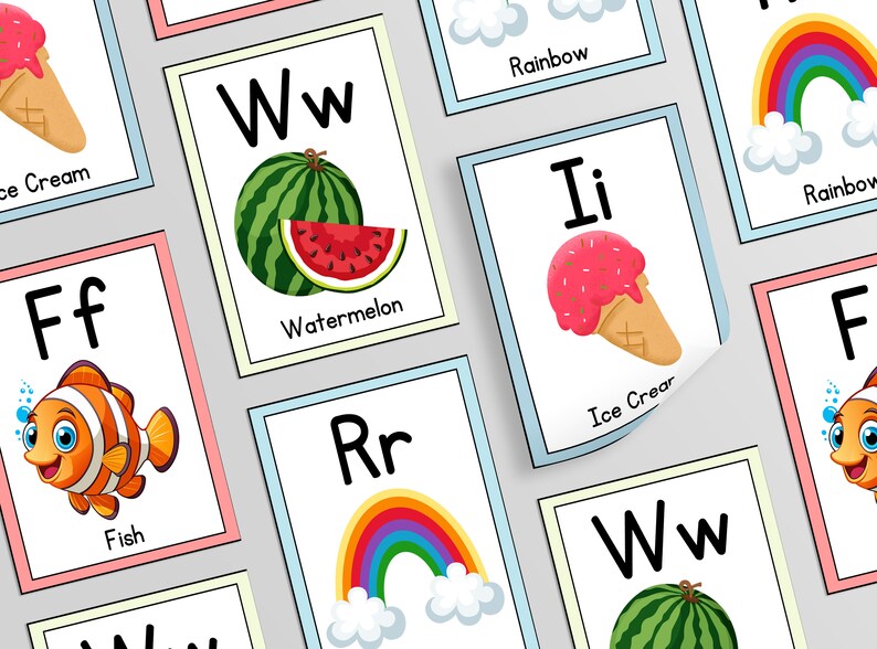 Op de afbeelding: Een set alfabetkaarten met kleurrijke illustraties van verschillende objecten. Elke kaart heeft een letter van het alfabet, een afbeelding en het woord voor de afbeelding. De letters zijn in hoofdletters en kleine letters. De afbeeldingen omvatten een regenboog, een watermeloen, ijs, een vis en een clownvis.