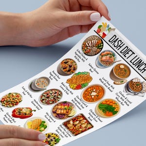 Puede incluir: Un men&uacute; impreso titulado "DASH DIET LUNCH" con ilustraciones de varias opciones de comidas saludables. El men&uacute; incluye platos como pollo a la parrilla, taz&oacute;n de quinoa con salm&oacute;n, sopa de lentejas y curry de pollo. El men&uacute; es sostenido por una persona.
