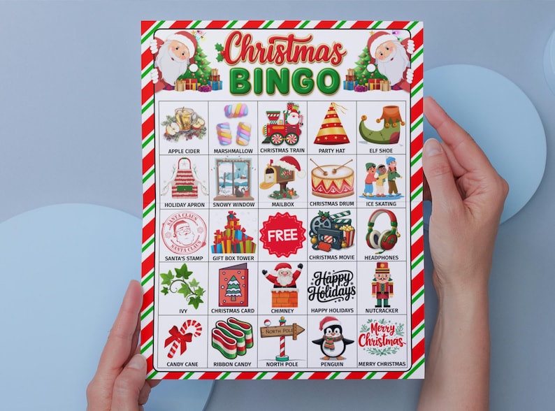 May include: A Christmas Bingo game card with a red and green striped border. The card features festive illustrations and the words "Christmas Bingo" in a colorful font. The card is held by two hands.