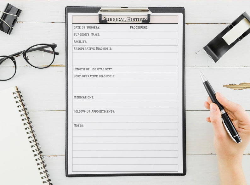 May include: A black clipboard with a white sheet of paper titled "Surgical History". The paper has lines for recording information such as date of surgery, surgeon's name, facility, pre-operative diagnosis, procedure, length of hospital stay, post-operative diagnosis, medications, follow-up appointments, and notes.