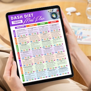 May include: A tablet displaying a 7-day DASH diet meal plan. The screen features a purple banner with the text "DASH DIET Meal Plan" and a colorful grid detailing breakfast, lunch, dinner, and snack options for each day of the week.