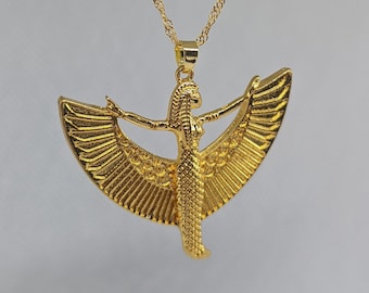 May include: A gold-toned pendant necklace featuring a detailed depiction of the Egyptian goddess Isis with outstretched wings.