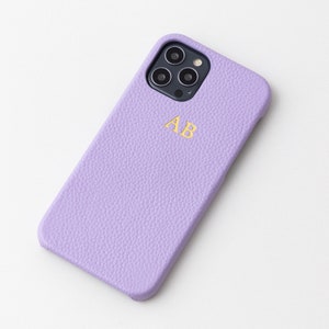 May include: A lavender leather phone case with a gold monogram "AB" and a camera cutout.