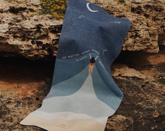 Puede incluir: Una esterilla de yoga rectangular con un cielo nocturno azul oscuro, una luna creciente y estrellas. Una figura en traje de baño rojo levanta los brazos, emitiendo un haz de luz blanca. El texto dice: NO MATTER WHAT PHASE I AM ALWAYS WHOLE.