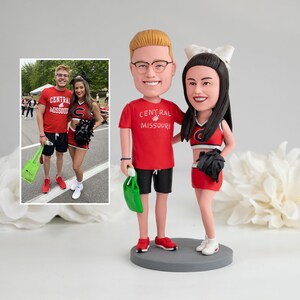 a couple of people standing next to each other bobble head