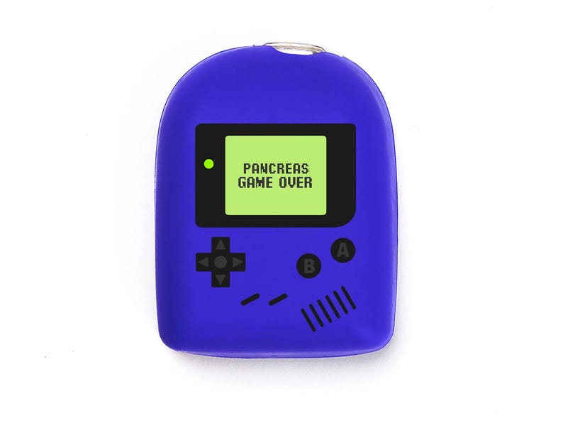 May include: A blue novelty keychain in the shape of a retro handheld games console. The screen shows "PANCREAS GAME OVER" in white text on a green background. Black buttons and a directional pad are featured on the front.