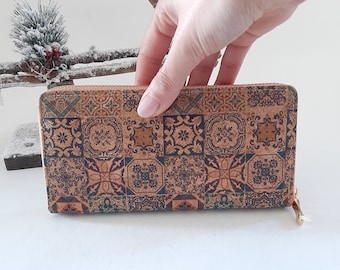 May include: A brown cork wallet with a zipper closure. The wallet has a colorful patterned design with geometric shapes and floral motifs.
