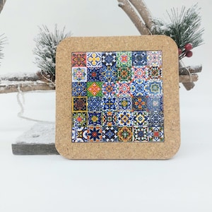 May include: A cork coaster featuring a colourful design of Portuguese tiles. The tiles are blue, green, yellow and red. The coaster has a brown cork border.