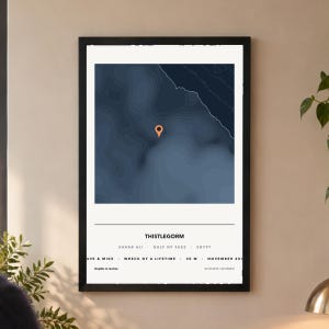 May include: A framed wall art print featuring a dark blue bathymetric map of the Thistlegorm wreck site in the Gulf of Suez, Egypt. The map includes an orange location pin, the text Thistlegorm, Sha'ab Ali, and coordinates 27.8123 N / 33.9300 E.