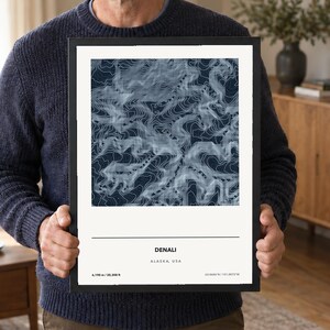 May include: A framed topographic map print of Denali, Alaska, USA, featuring white contour lines on a dark blue background. The print includes the text Denali, Alaska, USA, 6,190 m / 20,308 ft, and coordinates 63.0686°N / 151.0072°W on a white border.