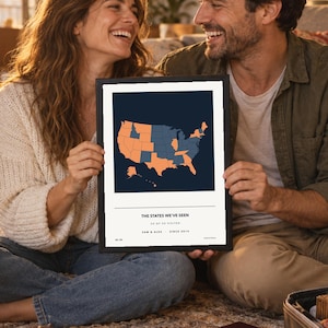 May include: A framed wall art print featuring a dark blue map of the United States with select states highlighted in orange. The text reads THE STATES WE'VE SEEN, 26 OF 50 VISITED, SAM & ALEX - SINCE 2014, and 26/50 in a clean, minimalist layout.