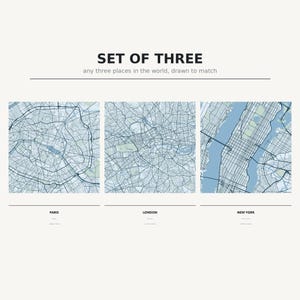 Peut inclure: Un ensemble de trois impressions de cartes carrées représentant Paris, Londres et New York dans des tons de bleu et de gris. Le texte indique SET OF THREE any three places in the world, drawn to match, avec les noms PARIS, LONDON, NEW YORK.