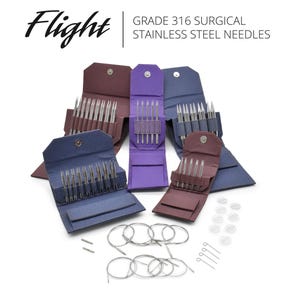 May include: An assortment of knitting needles and accessories are displayed on a white background. The image features several open cases in shades of purple, blue, and burgundy, each containing multiple needles. The text "Flight" and "GRADE 316 SURGICAL STAINLESS STEEL NEEDLES" are visible.