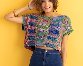 May include: A colorful, multi-colored, crocheted top with short sleeves and a cropped length. The top is made with a variety of colors, including blue, green, purple, and pink. The top is worn with blue jeans.