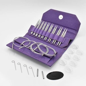 May include: A purple knitting needle set with various sizes of silver needles, circular cables, stitch markers, and other accessories. The set is contained in a purple case with a snap closure. The needles are arranged in a row.