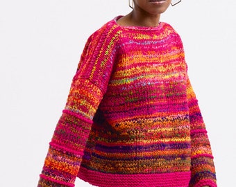 May include: A colorful striped sweater with a pink base and long sleeves. The sweater has a relaxed fit and a slightly cropped length.