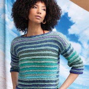 Può includere: Un maglione a righe in tonalità di blu, verde e viola. Il maglione ha una vestibilità rilassata e una lunghezza leggermente corta.