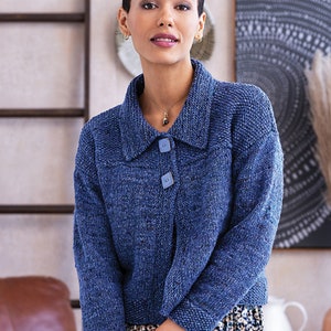 May include: A blue knitted cardigan with a collar and button closure. The cardigan has a textured knit pattern and is worn over a floral print dress.