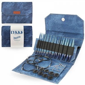 May include: A blue denim knitting needle case with a zipper closure. The case is open to reveal a set of interchangeable circular knitting needles, cords, and accessories. The case has the text "LYKKE MAKE HAPPY INDIGO Interchangeable Circular Knitting Needle Set" printed on the front.