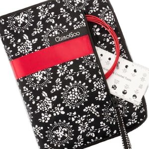 Peut inclure: Étui à aiguilles à tricoter ChiaoGoo noir et blanc à motifs floraux avec un accent rouge. L'étui est ouvert, révélant des aiguilles à tricoter circulaires rouges et un outil de jauge. L'étui a une fermeture éclair.