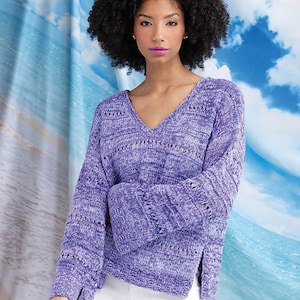 May include: A purple open-knit sweater with a V-neck and long sleeves. The sweater has a loose fit and a slightly cropped length.