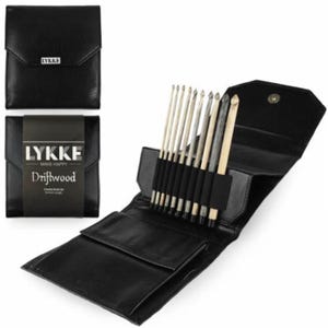 Puede incluir: Una funda de cuero negro con cierre de cremallera, que contiene un juego de 14 agujas de tejer. La funda tiene el texto "LYKKE MAKE HAPPY Driftwood Crochet Hook Set" impreso en la parte delantera.