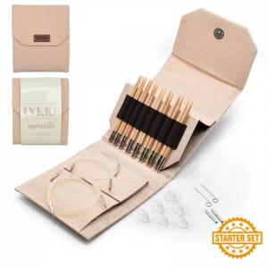 May include: A beige fabric knitting needle set with multiple needles, cables, and accessories. The set includes a variety of wooden needles secured by a black band, clear circular cables, and small clear plastic stitch markers. The set is labeled "Starter Set".
