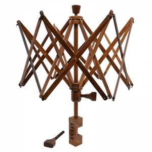May include: A wooden yarn swift with a clamp base and a Lykke logo. The swift is made of brown wood and has a starburst design. It is used to wind yarn into a ball.