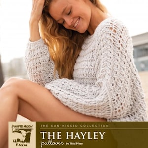 Pode incluir: Um pulôver cinza claro de malha aberta com mangas compridas. O texto "THE HAYLEY pullover" é exibido na parte inferior da imagem. O pulôver faz parte da "THE SUN-KISSED COLLECTION" da Third Piece.
