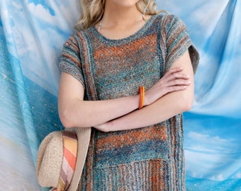 May include: A blue, orange, and grey striped knit top with short sleeves. The top has a relaxed fit and a slightly longer length. The model is wearing the top with a straw hat and a scarf.
