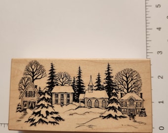Sello de goma vintage con escena de pueblo invernal: iglesia y casas nevadas. Sello montado en madera de PSX de 1995.