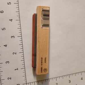 May include: A rectangular wooden stamp with a black and red rubber stamp pad. The stamp has a barcode and the text "P50674" and "2012-05-15 1083870" printed on it. The stamp is approximately 3 inches long.