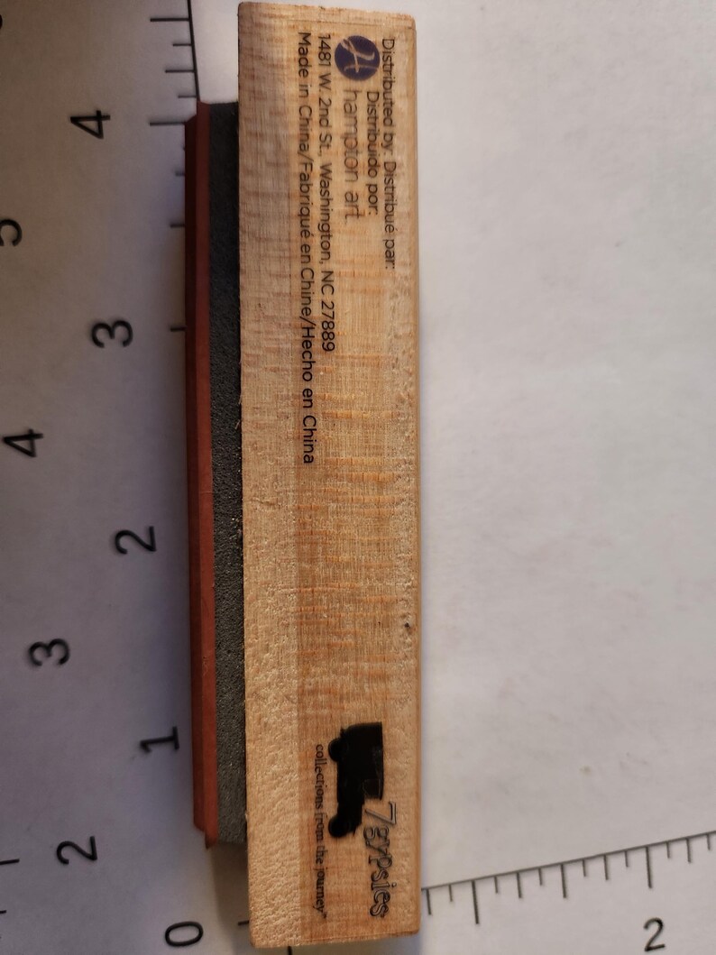 May include: A wooden stamp with a black boot silhouette and the text "7gypsies collections from the journey." The stamp has a black and red rubber base. The stamp is marked "Distributed by: Hampton Art, Made in China."