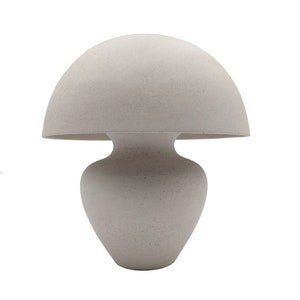 May include: A white ceramic table lamp shaped like a mushroom with a rounded top and a wide base.