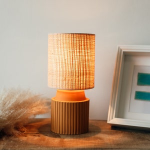 Handgesneden keramieken nachtkastjelamp oranje met raffia/rotan of witte kap